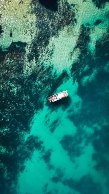 From Lagos: Ponta da Piedade Caves Kayak Tour from Catamaran - Sliding into the kayak and entering the caves